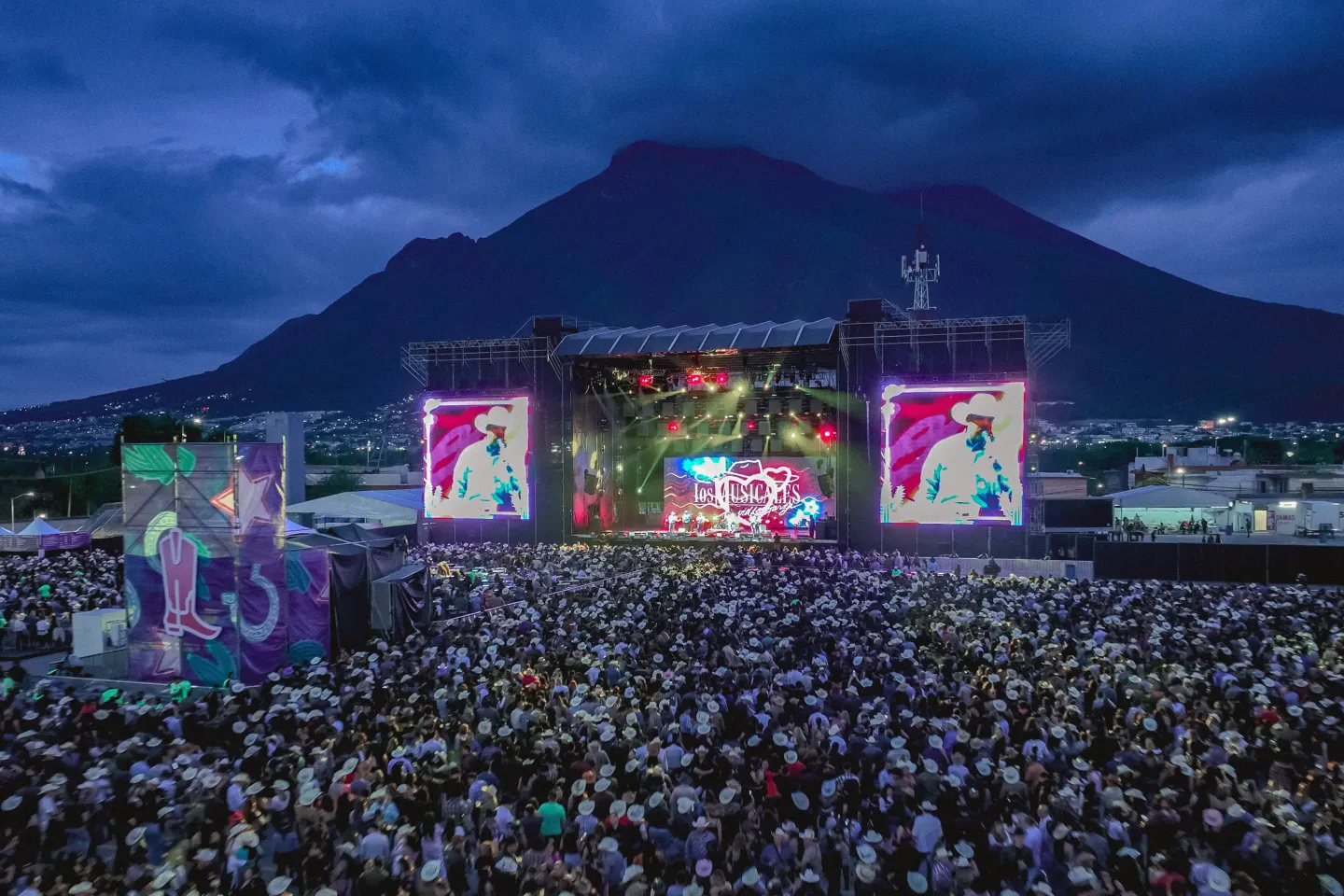 Escenario principal al atardecer, con el cerro de fondo y el público llenando la explanada