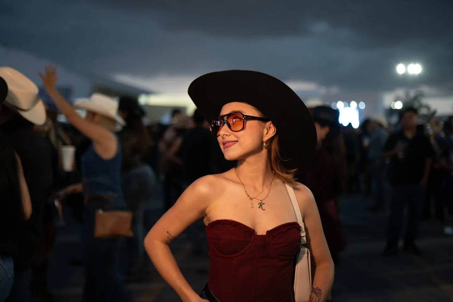 Asistente sonriendo con sombrero y lentes de sol